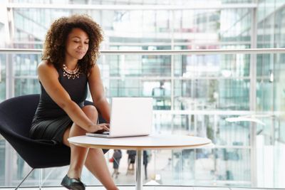 Young businesswoman using laptop computer in modern...