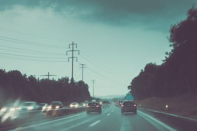 Cars on a highway at a rainy dusk (shallow DOF; color...
