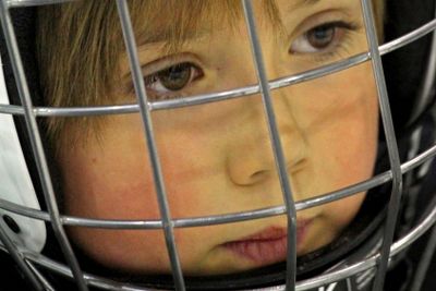 Ung hockeykille bakom galler