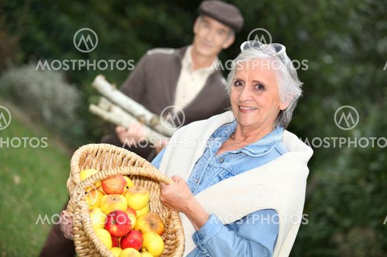 Elderly couple collecting objects in the forest