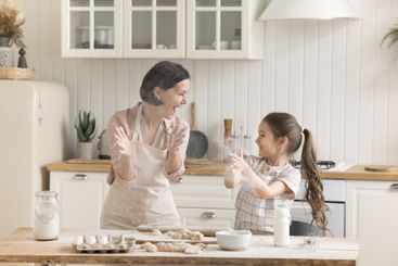 Joyful senior grandmother playing with excited little...