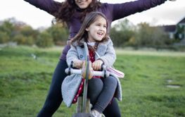 Joyful mother and little daughter smiling while playing...