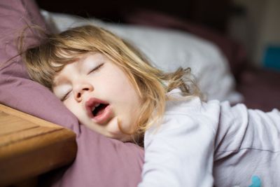 funny face of child sleeping on king bed