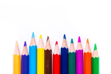 Colorful array of sharpened pencils lined up against a...