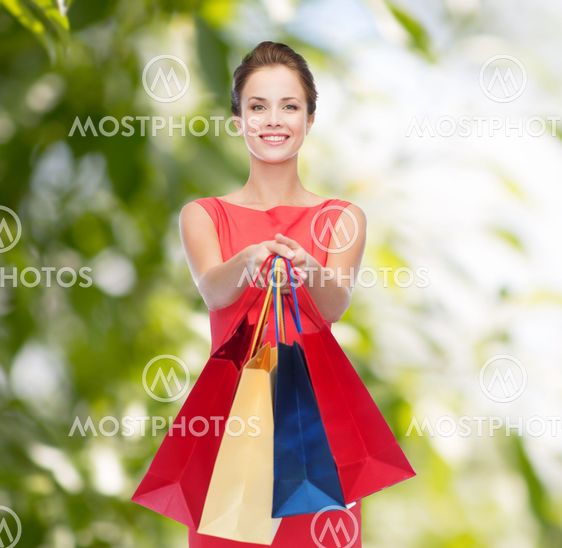 smiling elegant woman in dress with shopping bags