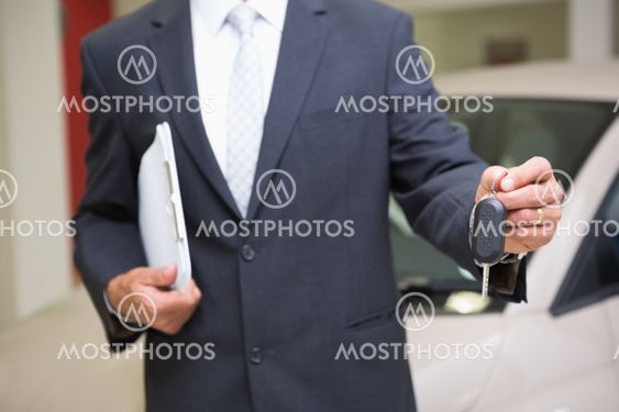 Close up of businessman holding car key and clipboard