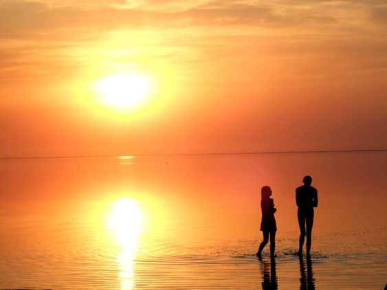 A black silhouette of a children on a sunset