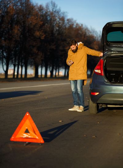 Man examining damaged automobile cars after breaking
