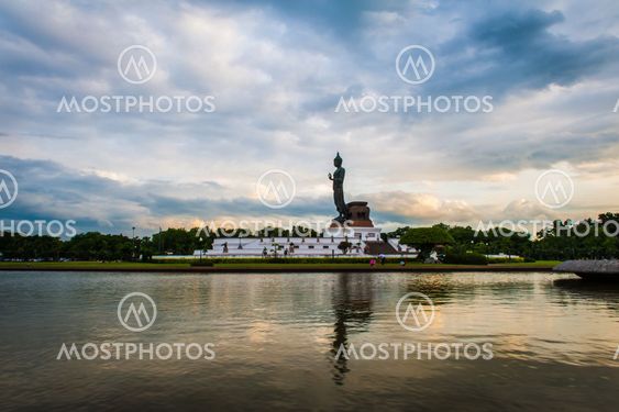 Sunset over walking Buddha statue at Buddhamonthon (Phutthamonthon), Buddhist Park in Nakhon Pathom, Thailand