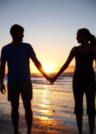 Couple, silhouette and holding hands by sea, sunrise and...