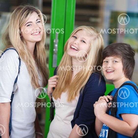 Three cheerful students standing chatting