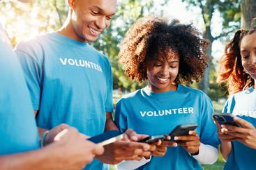 Volunteers, charity and people with phone, outdoor and...