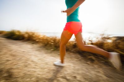 Young woman on her evening jog along the seacoast (motion...
