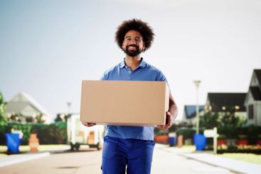 African American man in uniform smiling while delivering...