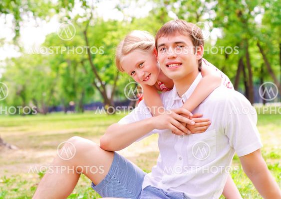Father and daughter sitting together on the grass