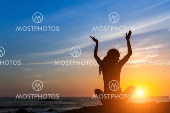 Meditation girl on the ocean during sunset. Yoga...