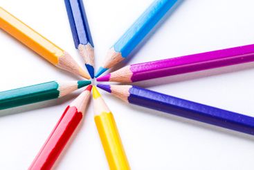 Colorful pencils arranged in a circular pattern on a...