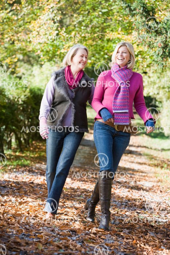 Mother and grown up daughter on walk through woods