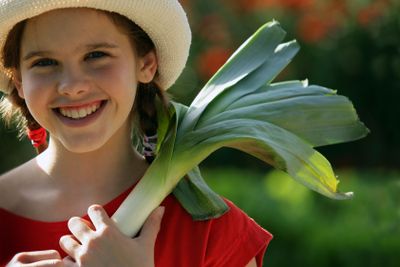 Child holding a leek
