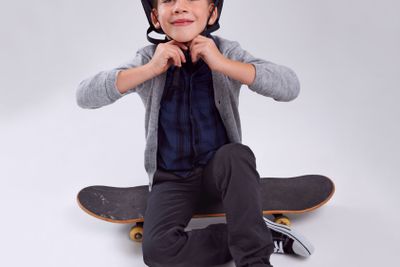 Smile, skateboard and portrait of child in studio with...