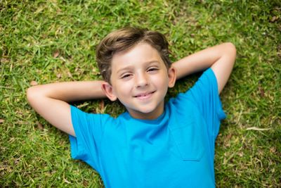 Young boy lying on grass