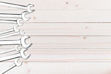 Collection of wrenches arranged on a wooden surface for...