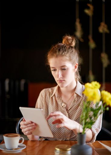 Tablet, search and woman in coffee shop with remote...