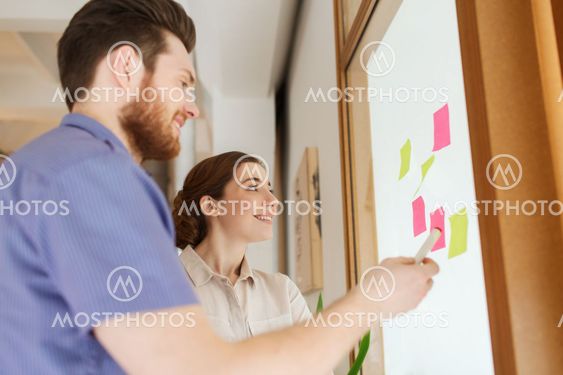 creative team with stickers on glass at office