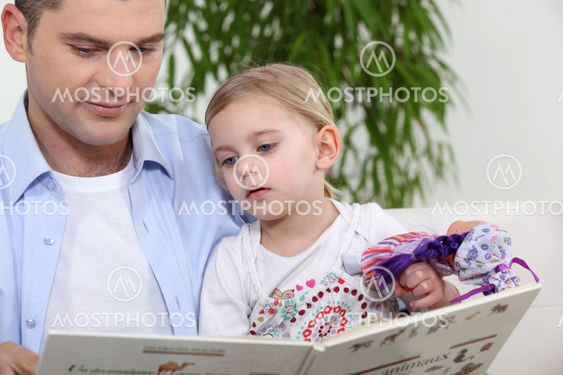 Father with daughter reading book
