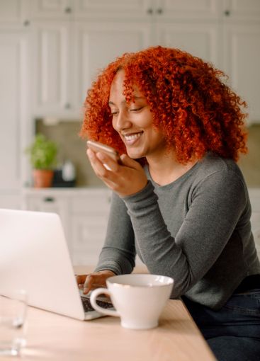 Smiling young businesswoman talking through smart phone...