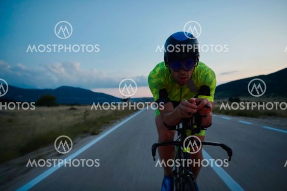 triathlon athlete riding bike at night