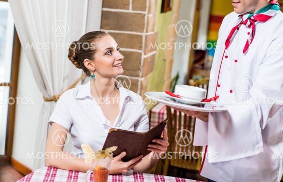 waiter brings a dish for a nice woman