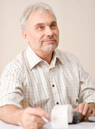 Senior mature man - home office paper tape calculator