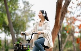 An asian woman is listening to the music playing in...