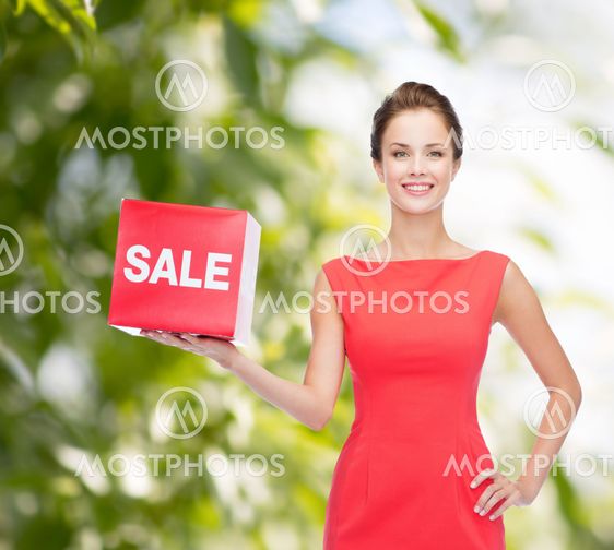 smiling young woman in dress with red sale sign