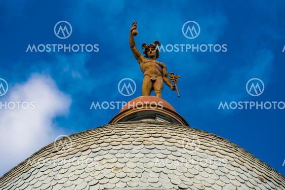 Statue of Mercury on top of the roof of a building in...