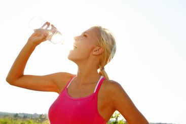 Woman, fitness or drinking with water bottle in nature...
