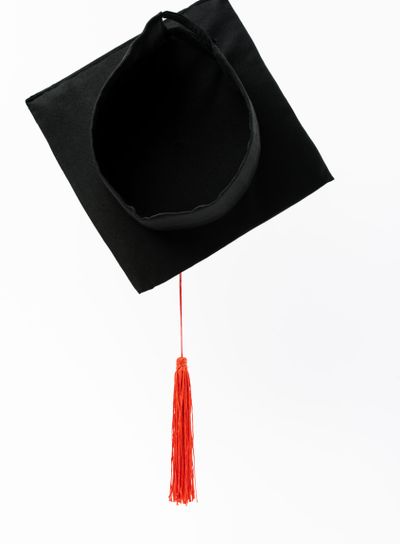Top view of black graduation cap with red tassel...