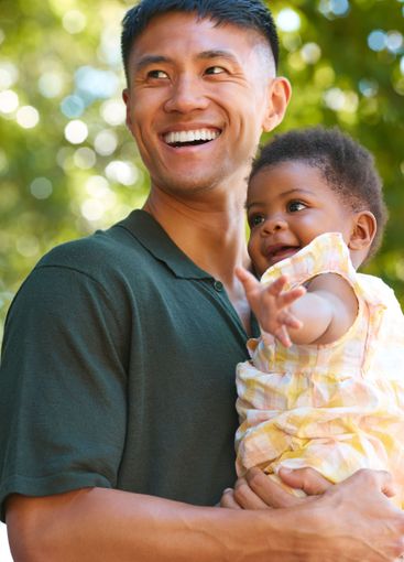 Family Shot With Loving Father Cuddling Baby Daughter...