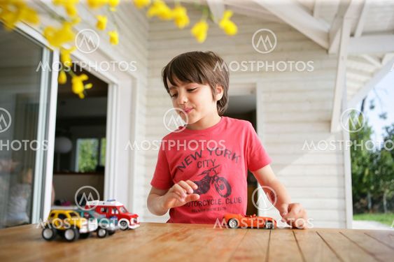 Young boy playing with his toy cars