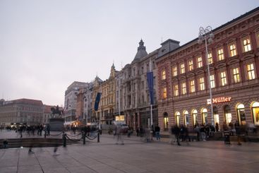 Tourists walking on ban jelacic square in zagreb at dusk