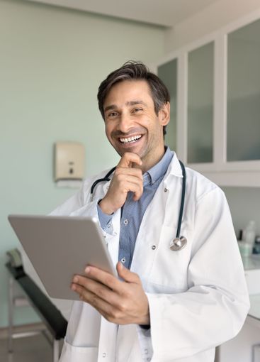 Cheerful Hispanic male general practitioner man using...