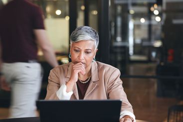 Business woman, serious and thinking on computer,...