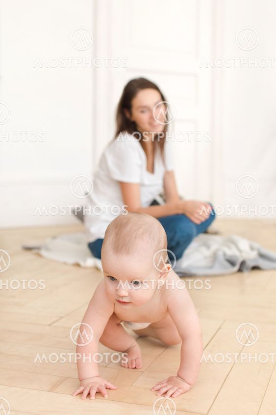 Woman watching baby crawling on floor