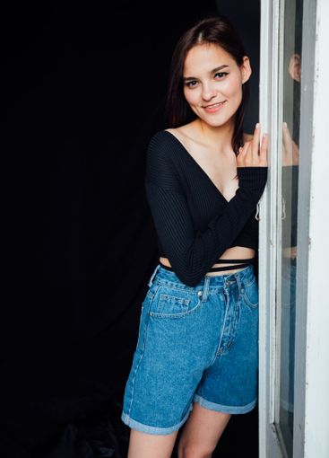 brunette woman and standing at the door from the room