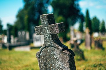 Old concrete christian cross tombstone on a cemetery...