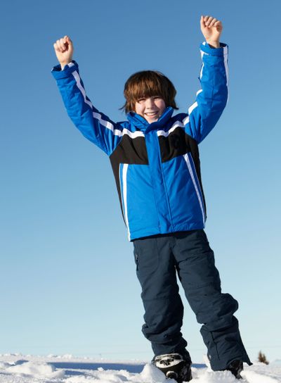 Young Boy Playing In Snow On Holiday In Mountains
