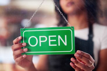 Female Owner Holding Closed Sign