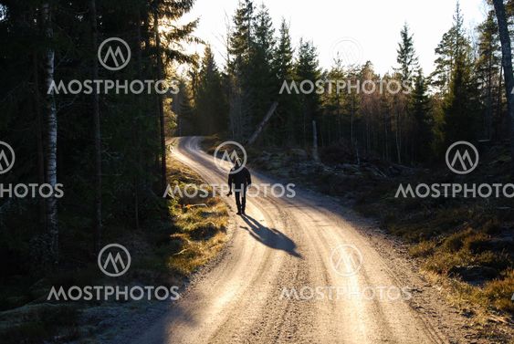 Man at a winding gravel road