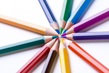 Colorful pencils arranged in a circular pattern on a...